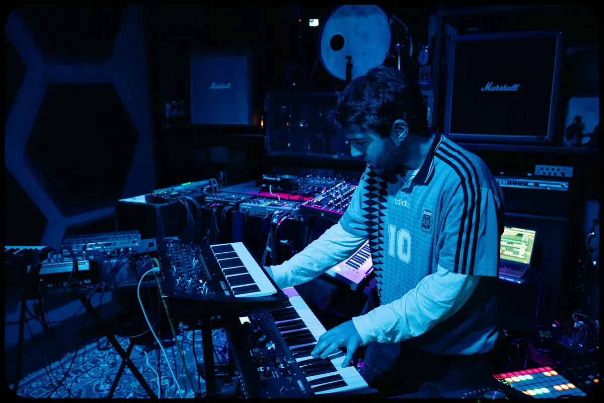 Musician playing keyboards and synths under blue light
