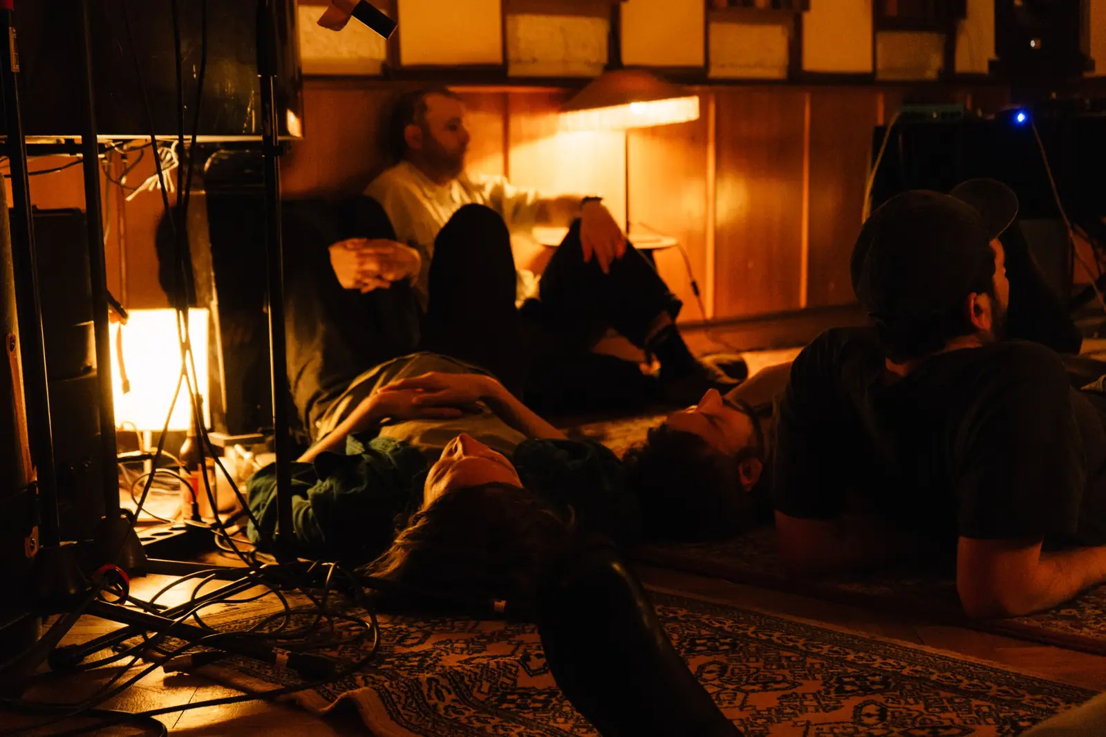Listeners resting in the warm light of the live room